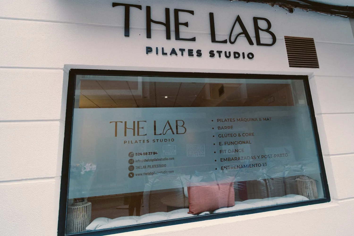 El escaparate de THE LAB en la calle Wenceslao Argumosa, con el rótulo y el listado de clases