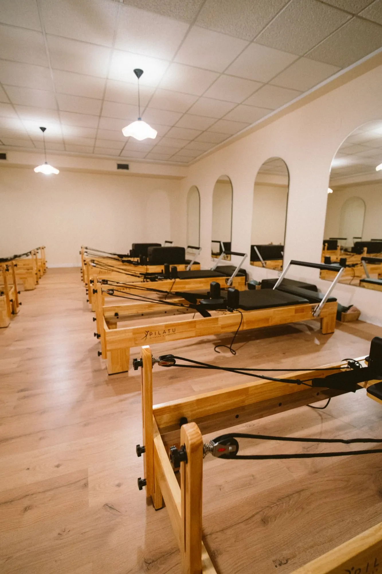 Sala principal de THE LAB con los reformers alineados frente a los espejos arqueados, estudio de Pilates en Guadalajara