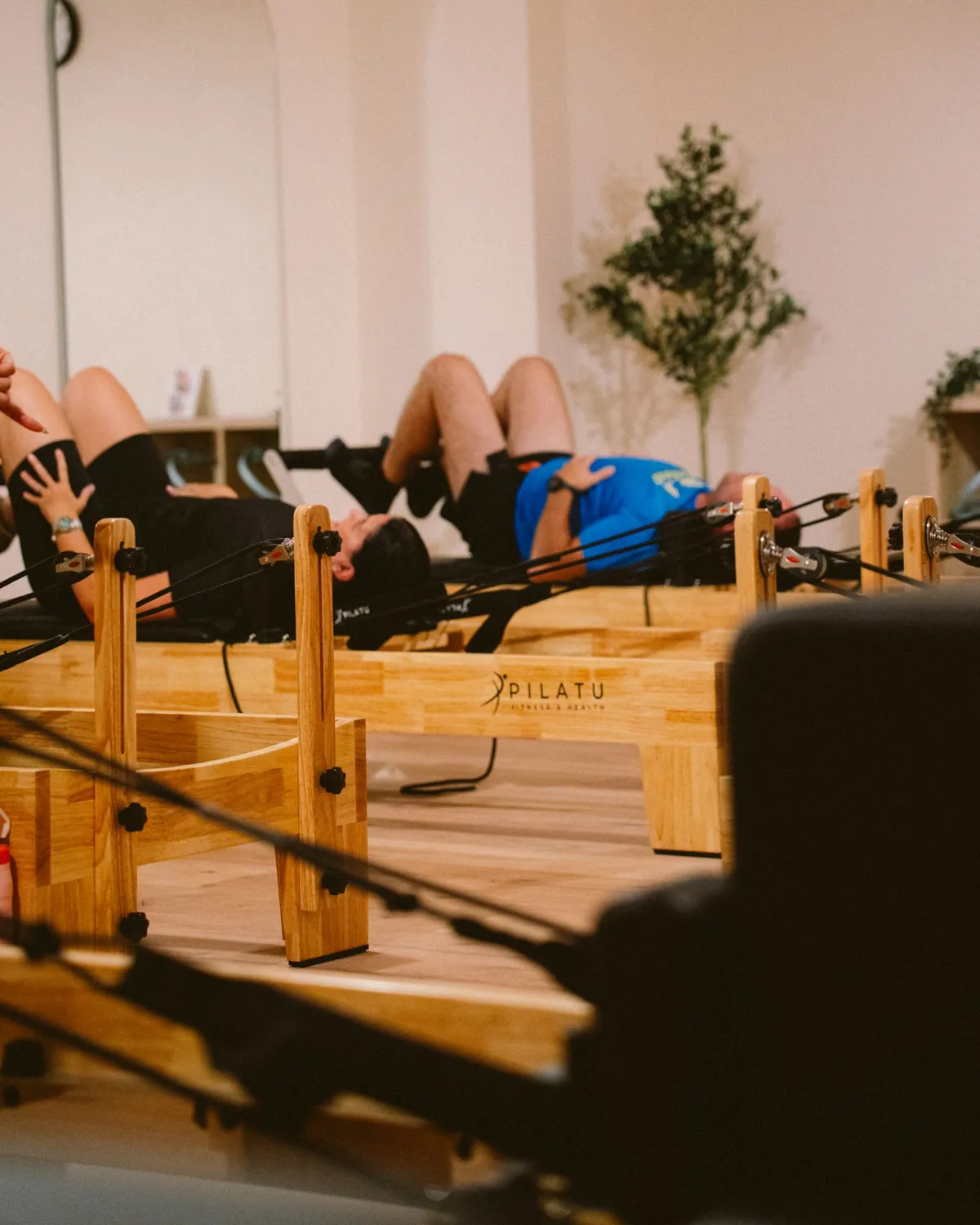Clase de Pilates Reformer en marcha en THE LAB: dos alumnos trabajando sobre las máquinas en el estudio de Guadalajara